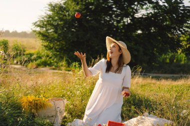 Turuncu şeftali meyvesiyle açık havada kaygısız yaz kızı..
