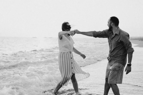Чорно-біле фото. Молода романтична пара танцює, обертаючись біля моря . — стокове фото