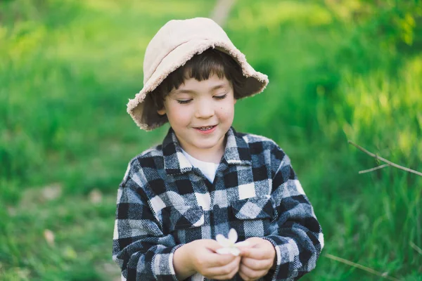 Kind spielt mit Ast eines Apfelbaums und hat Spaß. Frühlingsaktivität für wissbegierige Kinder — Stockfoto