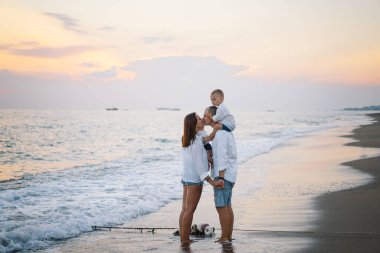 Mutlu bir aile, yaz tatilinde sahilde plaj oynarken eğleniyor..
