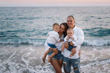 Mutlu bir aile, yaz tatilinde sahilde plaj oynarken eğleniyor..