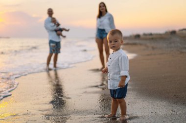Mutlu bir aile, yaz tatilinde sahilde plaj oynarken eğleniyor..