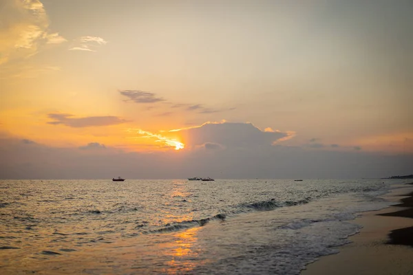 Hermosa puesta de sol con nubes de diferentes colores contra el cielo azul y el mar — Foto de Stock