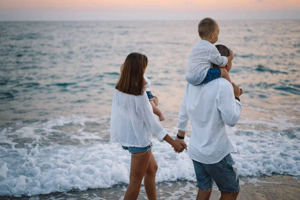 Mutlu bir aile, yaz tatilinde sahilde plaj oynarken eğleniyor..