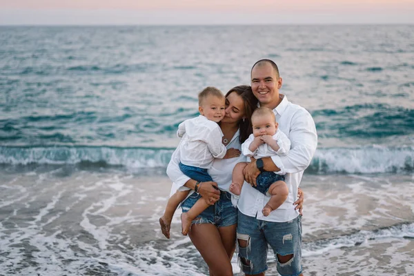 Mutlu bir aile, yaz tatilinde sahilde plaj oynarken eğleniyor..