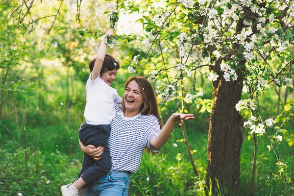 Buona festa della mamma. Madre con piccolo figlio nel giardino primaverile durante l'ora d'oro. Mamma e figlio — Foto Stock