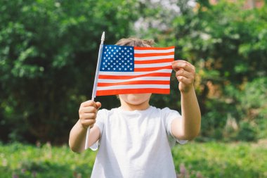 Küçük mutlu vatansever çocuk Amerikan bayrağı taşıyor..