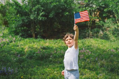Küçük mutlu vatansever çocuk Amerikan bayrağı taşıyor..