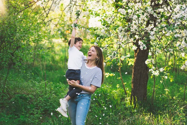 Feliz dia das mães. Mãe com filhinho no jardim da primavera durante a hora de ouro. Mãe e filho — Fotografia de Stock