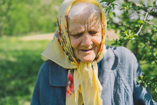 Retrato de uma velha mulher feliz em um lenço amarelo. — Fotografia de Stock