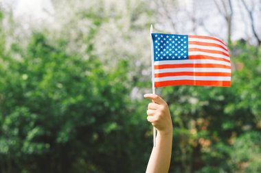 Amerikan bayrağı tutan küçük mutlu vatansever çocuk. ABD 4 Temmuz 'u kutluyor. Bağımsızlık günün kutlu olsun.