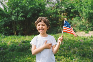 Amerikan bayrağı tutan küçük mutlu vatansever çocuk. ABD 4 Temmuz 'u kutluyor. Bağımsızlık günün kutlu olsun.