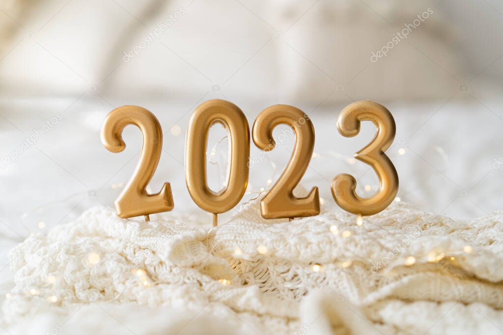 Happy New Years 2023. Christmas background with 2023 candles and white knit sweater. Christmas holiday celebration. New Year concept.