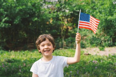 Amerikan bayrağı tutan küçük mutlu vatansever çocuk. ABD 4 Temmuz 'u kutluyor. Bağımsızlık günün kutlu olsun.
