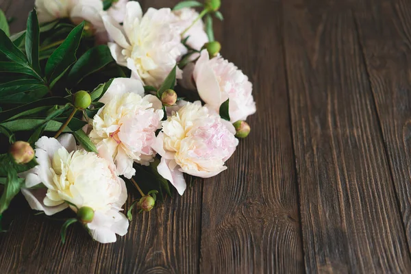 Ahşap arka planda buket beyaz, pembe şakayık çiçekleri. Minimalist estetik şakayıklar yatıyordu. Anneler Günü ya da Kadınlar Günü için güzel bir kart