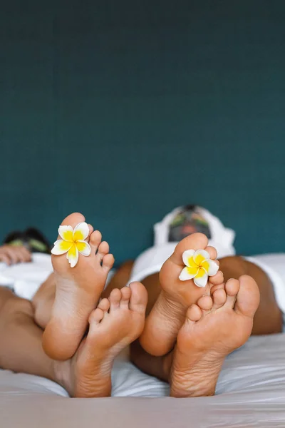 Spa treatment and product for woman hands and foot spa. Foot with tropical flowers. Healthy Concept. Closeup of beautiful female feet, legs at spa salon.