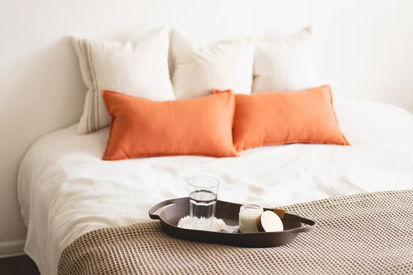 Linen pillows on a white bed with home decor. Still life details in home on a bed. Cozy home. Sweet home