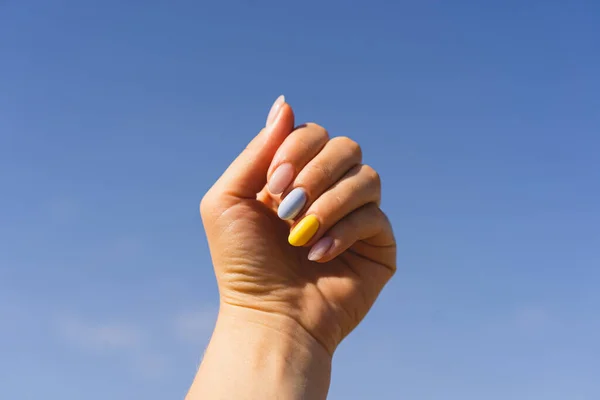 Yellow and blue manicure. Girl with manicure of ukrainian flag colors. Flag of Ukraine, freedom independence concept