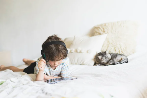 Aranyos Fiú Fekszik Ágyon Otthon Játszik Táblagép Vagy Online Olvasás — Stock Fotó