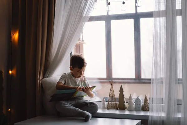 Cute Boy Reading Book Sitting Windowsill Window Cozy Home Decorative — Stock Fotó