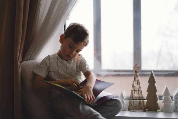 Cute Boy Reading Book Sitting Windowsill Window Cozy Home Decorative — Foto de Stock