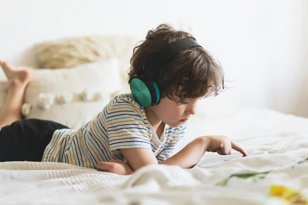Cute Boy Lying Bed Home Playing Tablet Reading Online Listening — Stok Foto