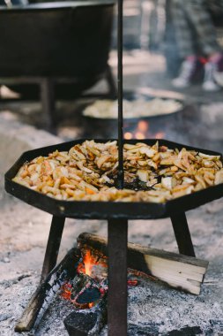 Hot food. Yummy potatoes are fried in a large skillet in oil outside. Fried potatoes in large kitchen pan. Street food.
