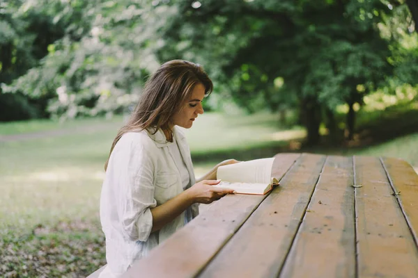 Woman Holds Book Her Hands Reading Book Sitting Bench Outdoors — Stockfoto