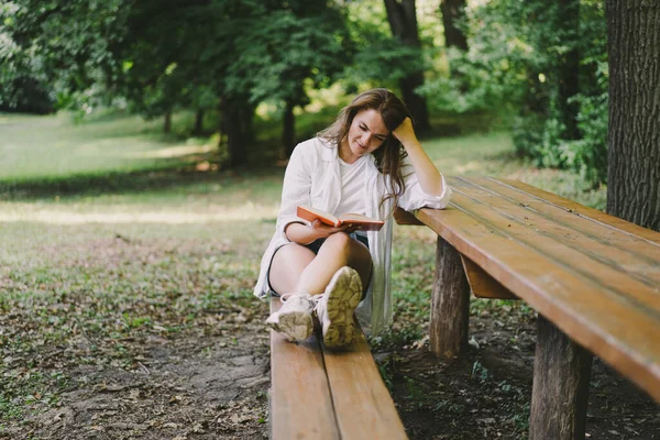 Woman Holds Book Her Hands Reading Book Sitting Bench Outdoors — Stock Fotó
