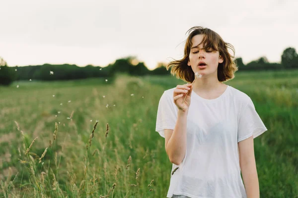 Gadis Remaja Cantik Lapangan Dengan Rumput Hijau Dan Meniup Dandelion — Stok Foto