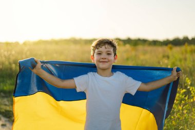 Ukraines Independence Day. Ukrainian child boy in white t shirt with yellow and blue flag of Ukraine in field. Flag of Ukraine. Constitution day. Stand with Ukraine and Save