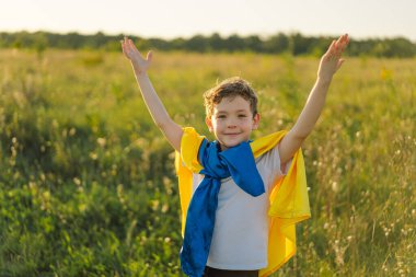 Ukraines Independence Day. Ukrainian child boy in white t shirt with yellow and blue flag of Ukraine in field. Flag of Ukraine. Constitution day. Stand with Ukraine and Save