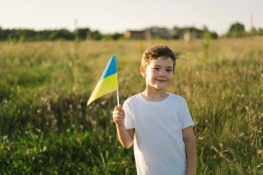 Ukraines Independence Day. Ukrainian child boy in white t shirt with yellow and blue flag of Ukraine in field. Flag of Ukraine. Constitution day. Stand with Ukraine and Save