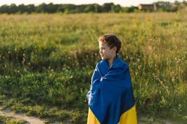 Ukraines Independence Day. Ukrainian child boy in white t shirt with yellow and blue flag of Ukraine in field. Flag of Ukraine. Constitution day. Stand with Ukraine and Save