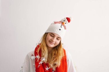 Noel şapkalı, kardan adam ve kırmızı eşarplı komik genç kız. Yeni yıl ve Noel konsepti.