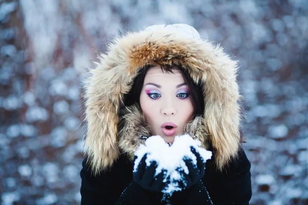 Jovem mulher em um capuz peludo nevado — Fotografia de Stock