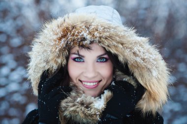 Beautiful winter portrait of young woman in the winter snowy sce clipart