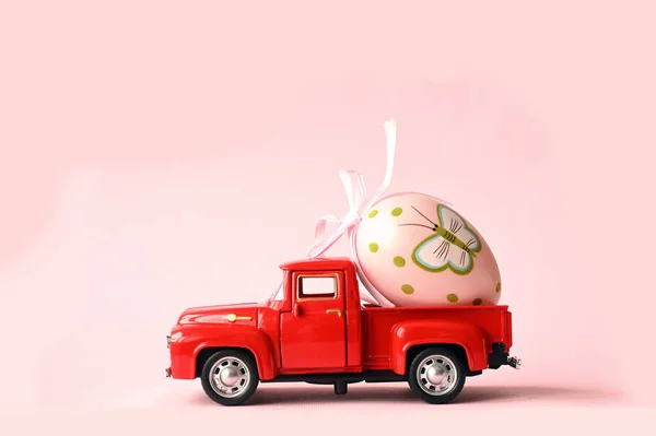 Jedno Jajko Wielkanocne Małym Samochodzie Różowym Tle Odbiór Wielkanoc — Zdjęcie stockowe