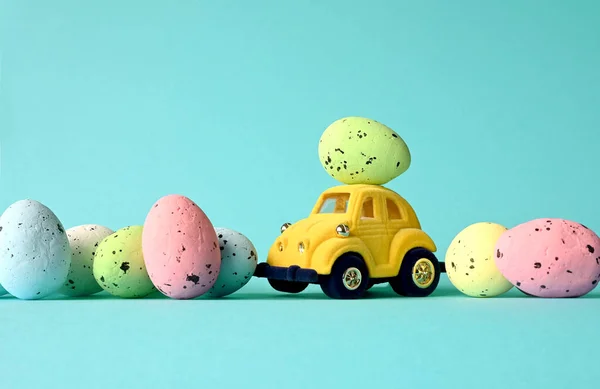 Jedno Jajko Wielkanocne Małym Samochodzie Niebieskim Tle Kolorowymi Jajkami Odbiór — Zdjęcie stockowe
