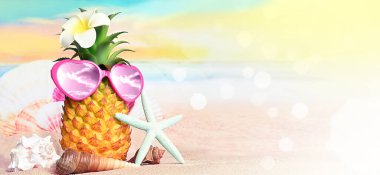Sıcak kumsalda ananas, denizyıldızı ve güneş gözlüğü olan tropikal bir deniz. Kopya alanı ile seyahat ve tatil kavramı.