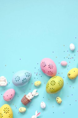Paskalya kompozisyonu. Pastel mavi arka planda Paskalya yumurtası ve Paskalya tavşanı. Minimum Paskalya konsepti. Düz konum, üst görünüm, kopyalama alanı