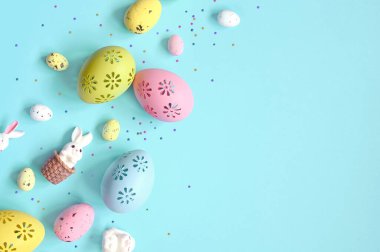 Paskalya kompozisyonu. Pastel mavi arka planda Paskalya yumurtası ve Paskalya tavşanı. Minimum Paskalya konsepti. Düz konum, üst görünüm, kopyalama alanı