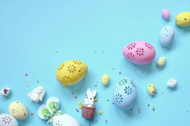 Paskalya kompozisyonu. Pastel mavi arka planda Paskalya yumurtası ve Paskalya tavşanı. Minimum Paskalya konsepti. Düz konum, üst görünüm, kopyalama alanı