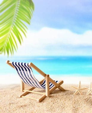 Vacation holidays background concept - beach lounge chair under palm on summer beach