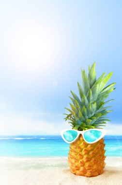 Tropik plaj arka planında güneş gözlüklü ananas. Yaz konsepti.