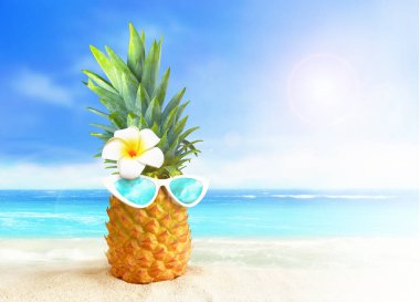 Tropik plaj arka planında güneş gözlüklü ananas. Yaz konsepti.