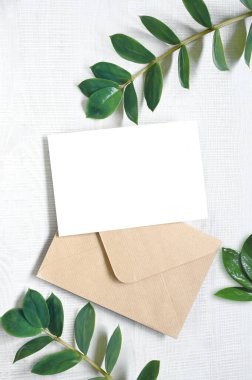 Mock up card with plants. Invitation card with grey envelope on white background.
