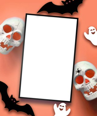 Turuncu arka planda Cadılar Bayramı süslemeleri. Mutlu Cadılar Bayramı konsepti. Balkabakları, kafatası, yarasalar, hayalet ve örümcekler yatıyordu