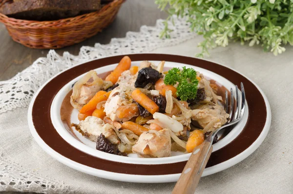 Куряче рагу з морквою і чорносливом на тарілці — стокове фото