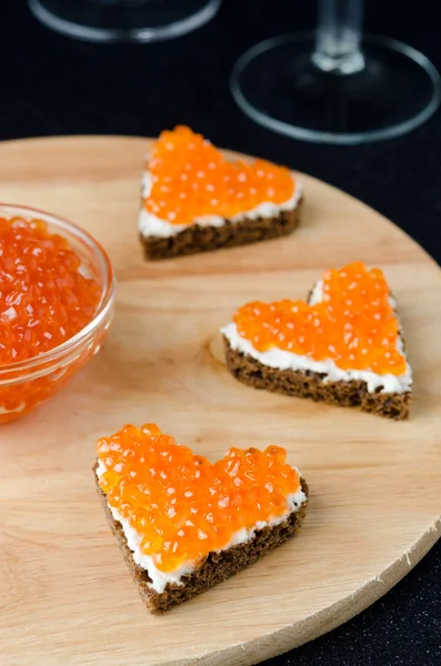 Three sandwich with red caviar in the form of a heart on board — Stock Photo, Image